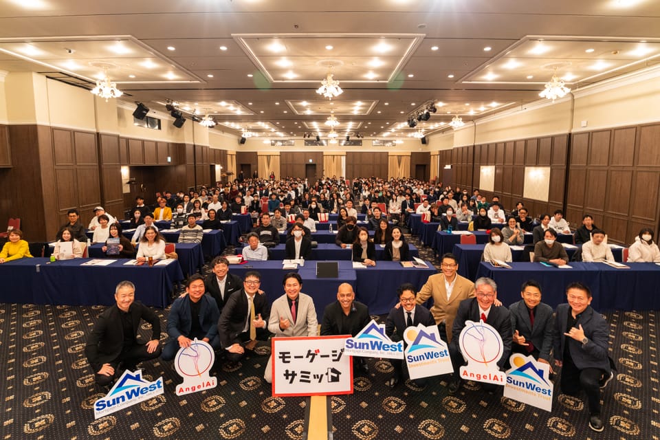 岡山会場の集合写真。登壇者と満席の来場者